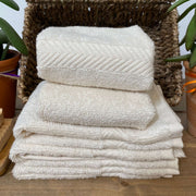 unbleached cotton face cloths stacked in a basket