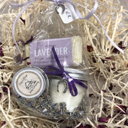relaxing lavender travel soap, soy wax candle and lip balm bundle on a bed of straw