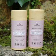 two cosy cottage natural deodorant sticks on a stone with moss in the background