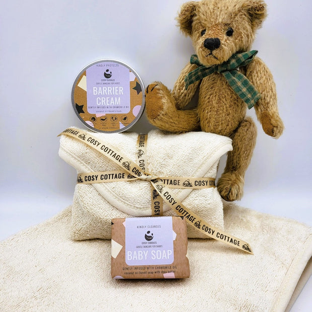 teddy bear with cosy cottage baby soap and barrier cream in a baby towel
