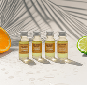 Four bottles of Cozy Cottage Sweet Orange & bergamot biodegradable Surface Cleaner on a light background with an orange and lime slice.