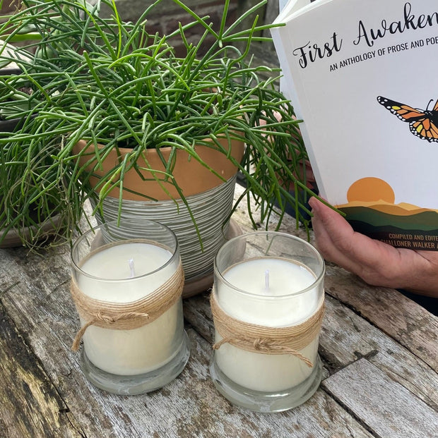 Two Cosy Cottage lemongrass soy wax candles in glass jars in an outdoor setting 