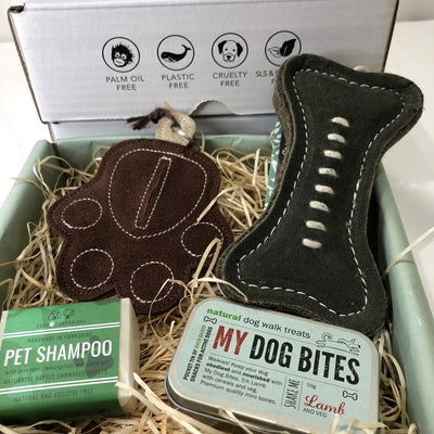 Cosy Cottage gift box containing pet shampoo, tin of dog treats, bone-shaped dog toy and paw shaped poop bag holder