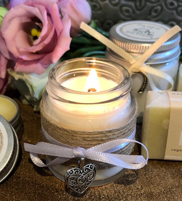 soy wax candle in small glass jar decorated with ribbon and heart-shaped charm