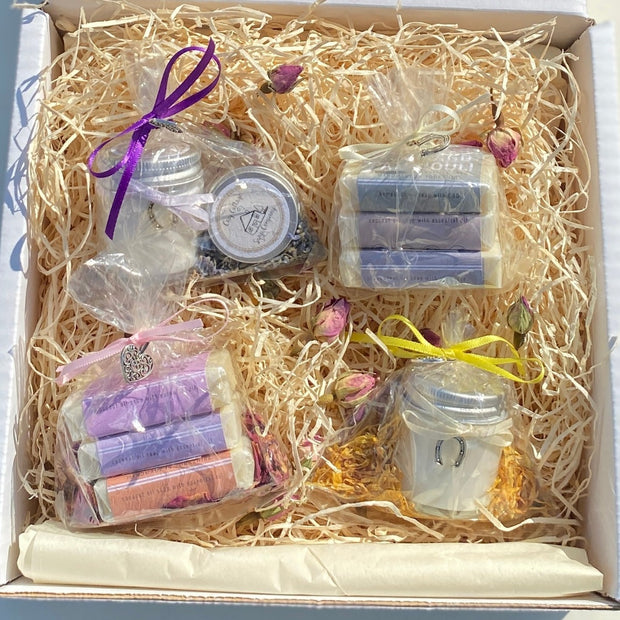 Wedding favour sample box containing Cosy Cottage products, mini candle, mini soaps and mini lip balm all wrapped and decorated with ribbons and metal charms