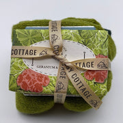 Cosy Cottage herb garden geranium and bergamot  soap with green woollen socks and 30g bar of milk chocolate tied in a bundle with Cosy Cottage ribbon