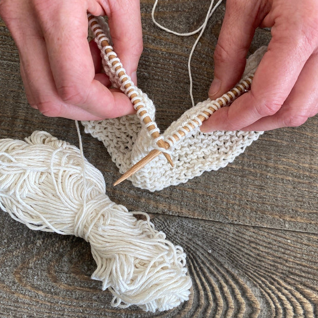 hands knitting a cotton dishcloth