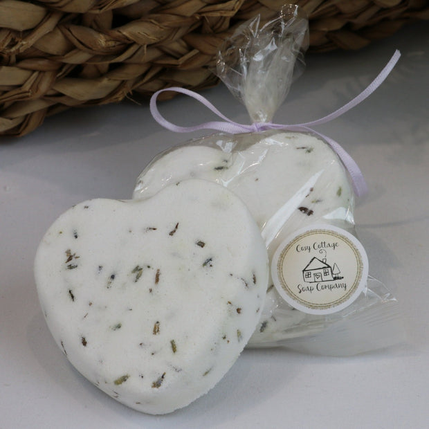 Heart shaped lavender bath bombs with ilavender flowers, wrapped in compostable cellulose
