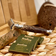 reusable bamboo and stainless steel razor with packs of razor blades on a wicker basket