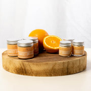 Cosy Cottage sweet orange hand and body balms with sliced oranges on a wooden block
