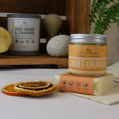 Cosy Cottage sweet orange soap and hand and body cream set with Cosy Cottage sweet orange and cinnamon candle in background