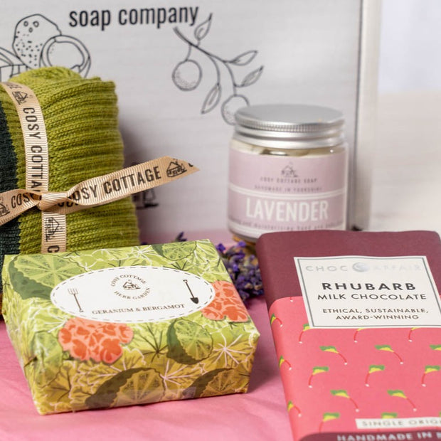  gift box containing geranium and bergamot soap, lavender hand and body cream, rhubarb chocolate and woollen socks