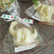 wrapped dinosaur shaped children's chamomile soaps on a wooden bench
