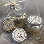soy wax candle and natural lip balm in front of a bundle in biodegradable packaging with cream ribbon